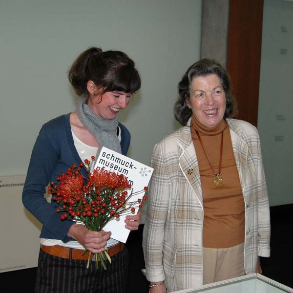 Susanne Wolbers nach Überreichung der Urkunde „Junge Schmuckkunst 2009“ durch die damalige ISSP-Vorsitzende Marie-Luise Auerbach-Fröhling, vor der Vitrine mit dem Förderankauf von der Schmuckkünstlerin